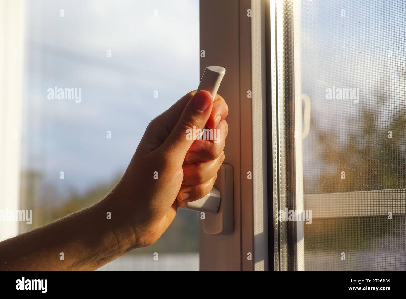 A woman hand opening a window using a window handle Stock Photo - Alamy