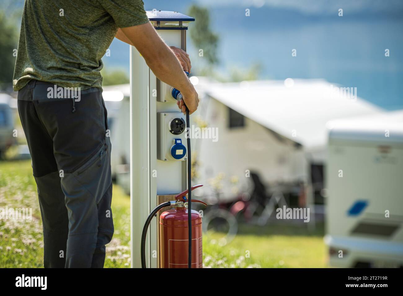 Motorhome RV Owner Attaching Power Cable to Camping Electric Post