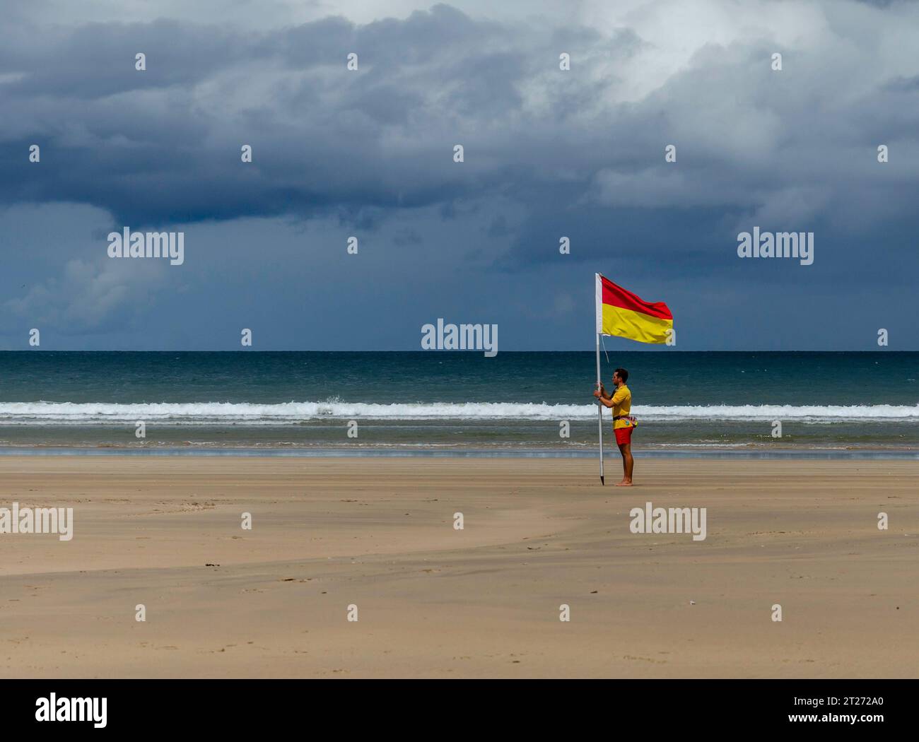 Downhill Strand, Downhill, County Londonderry, Northern Ireland July 05 2023 - Lifeguard placing a safe swimming flag on the beach Stock Photo