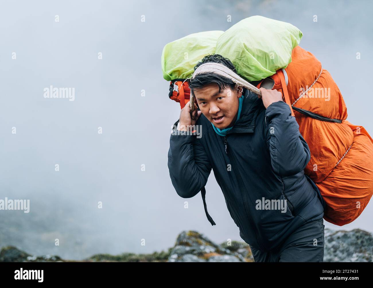 Sherpa Method. Sign Portrait of strong Sherpa man working as porter carrying a huge cargo ...