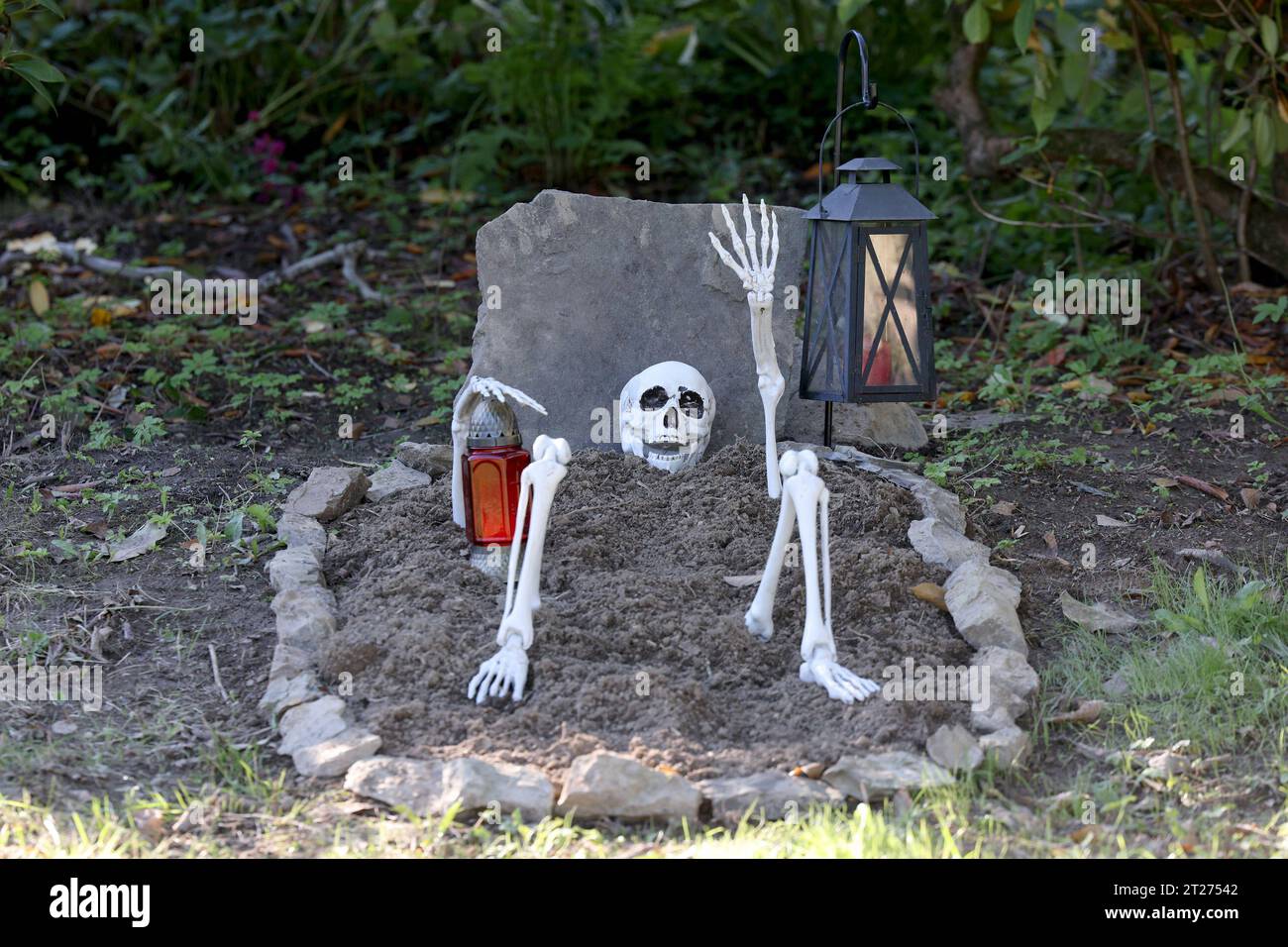 Symbolbild zum Thema Halloween, auf einer Wiese vor einem Haus in Kreuztal  wurde Halloween-Deko aufgebaut, Grab mit Skelett Symbolbild, Halloween, am  17.10.2023 in Kreuztal/Deutschland. *** Halloween symbol picture, on a  meadow in
