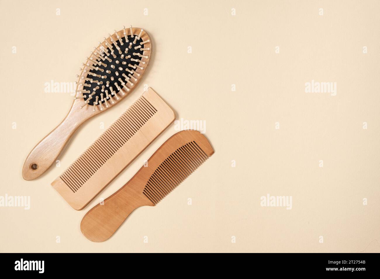 Wooden combs and hair care brush on beige background, top view, space for text. Stock Photo