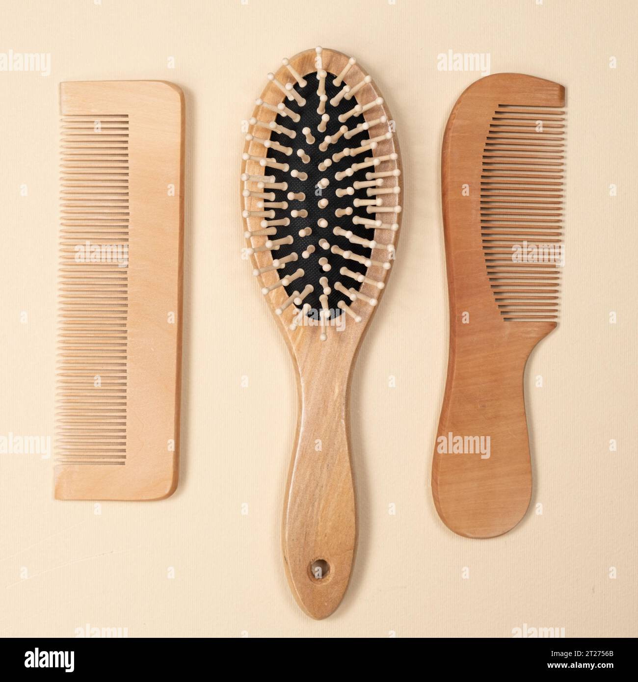Wooden combs and hair care brush on beige background, top view Stock Photo