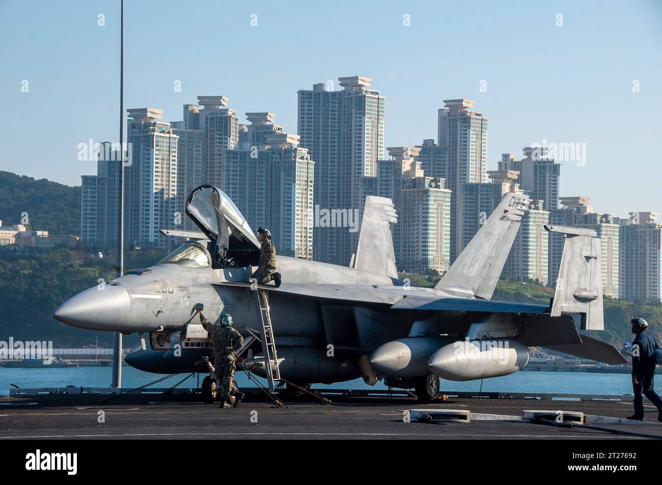 Busan, South Korea. 16th Oct, 2023. U.S. Navy sailors perform routine maintenance on a F/A-18E Super Hornet fighter jet, attached to the Royal Maces of Strike Fighter Squadron 27, on the flight deck of the Nimitz-class aircraft carrier USS Ronald Reagan as it departs, October 16, 2023 in Busan, South Korea. Credit: MC3 Heather McGee/U.S. Navy Photo/Alamy Live News Stock Photo