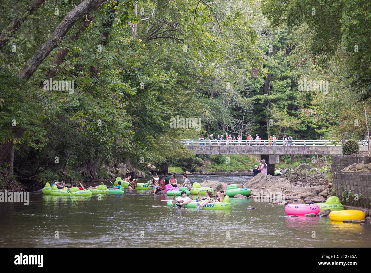 Helen, GA / USA - September 9, 2023:  Telephoto shot shows people tubing on the Chattahoochee River on a hot summer day. Stock Photo