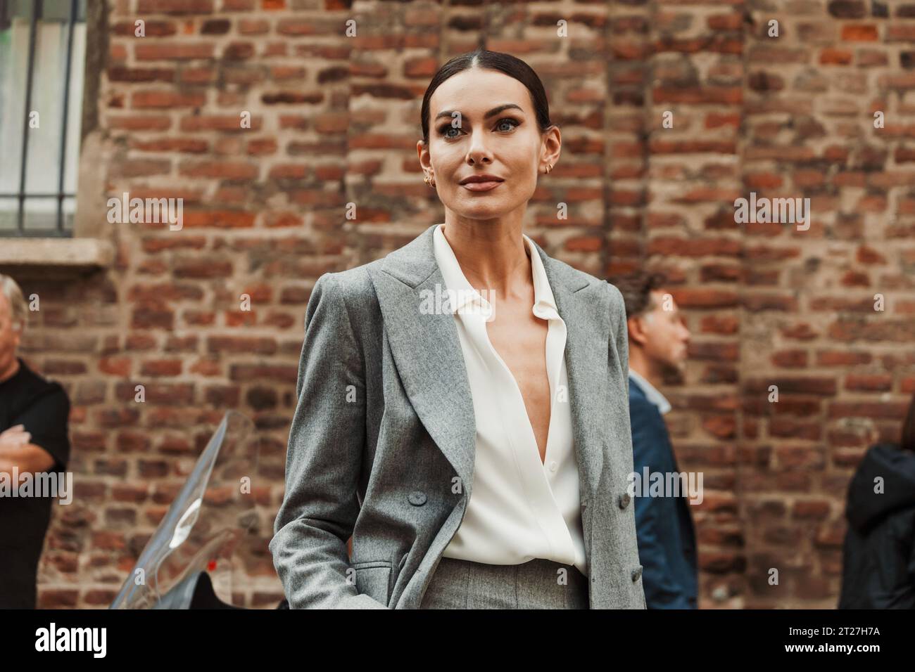 Paola Turani wears gray suit and white blouse, outside MAX MARA show