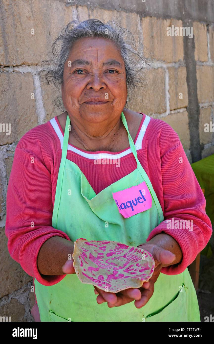 An elderly indigenous Ottomi woman holds a Tortillas Ceremoniales that she made with a special press and beet juice for coloring at the El Salto Salud Indigena women's cooperative outside San Miguel de Allende, Mexico. Stock Photo