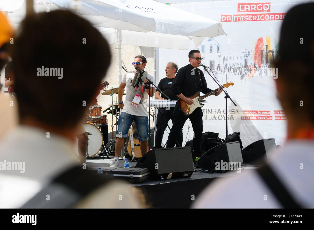 A band, including a catholic priest, giving a concert during World Youth Days 2023 in Lisbon, Portugal. The concert took place near the St Roch Church. Stock Photo