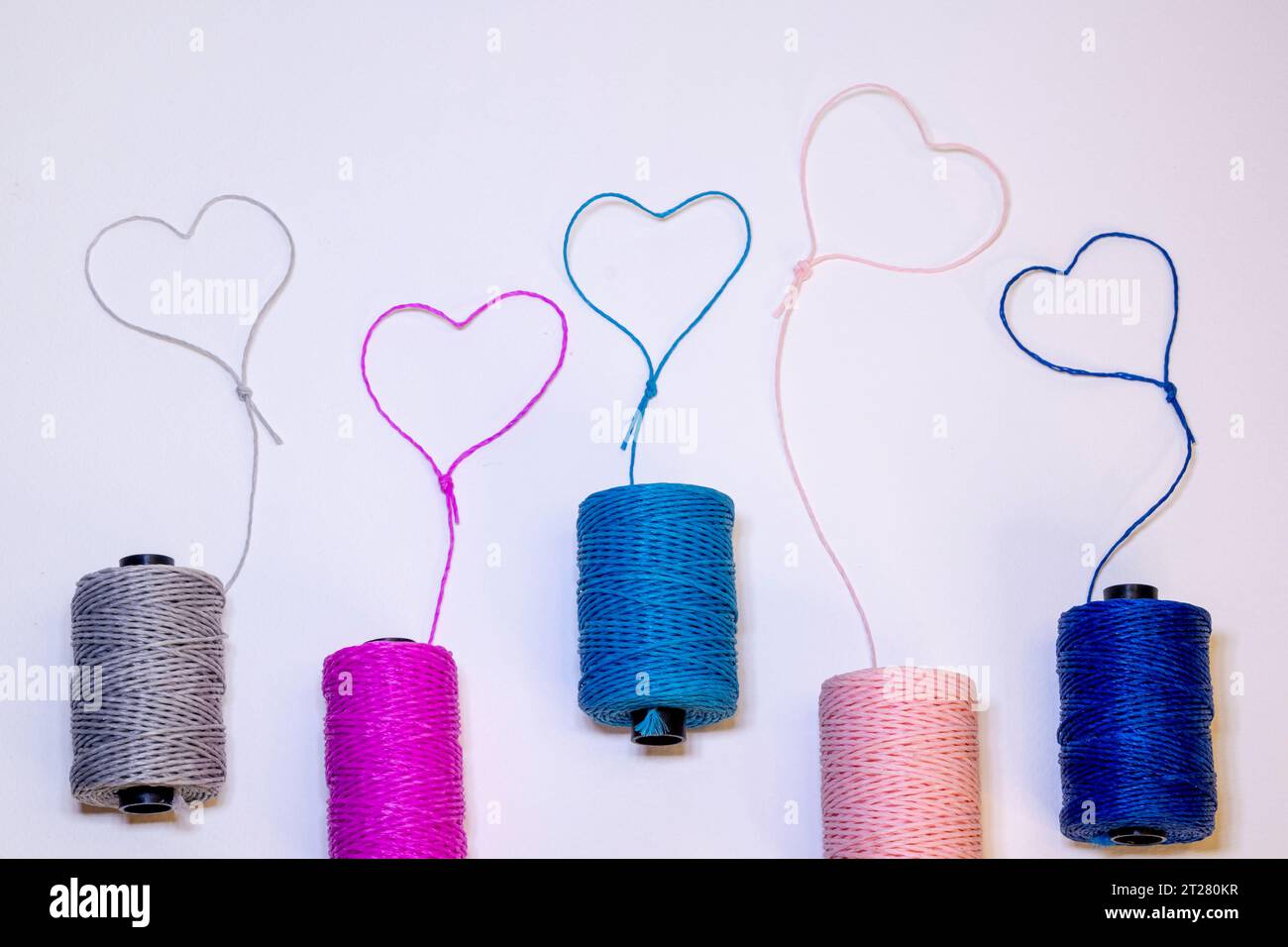 Conceptual art made with threads that form hearts on a light background. Stock Photo