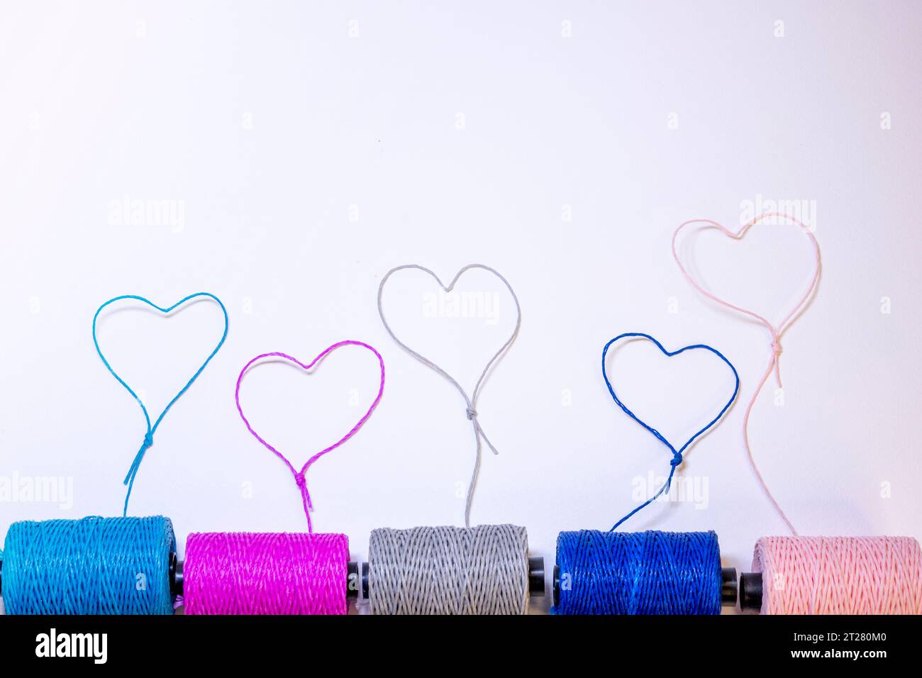 Conceptual art made with threads that form hearts on a light background. Stock Photo
