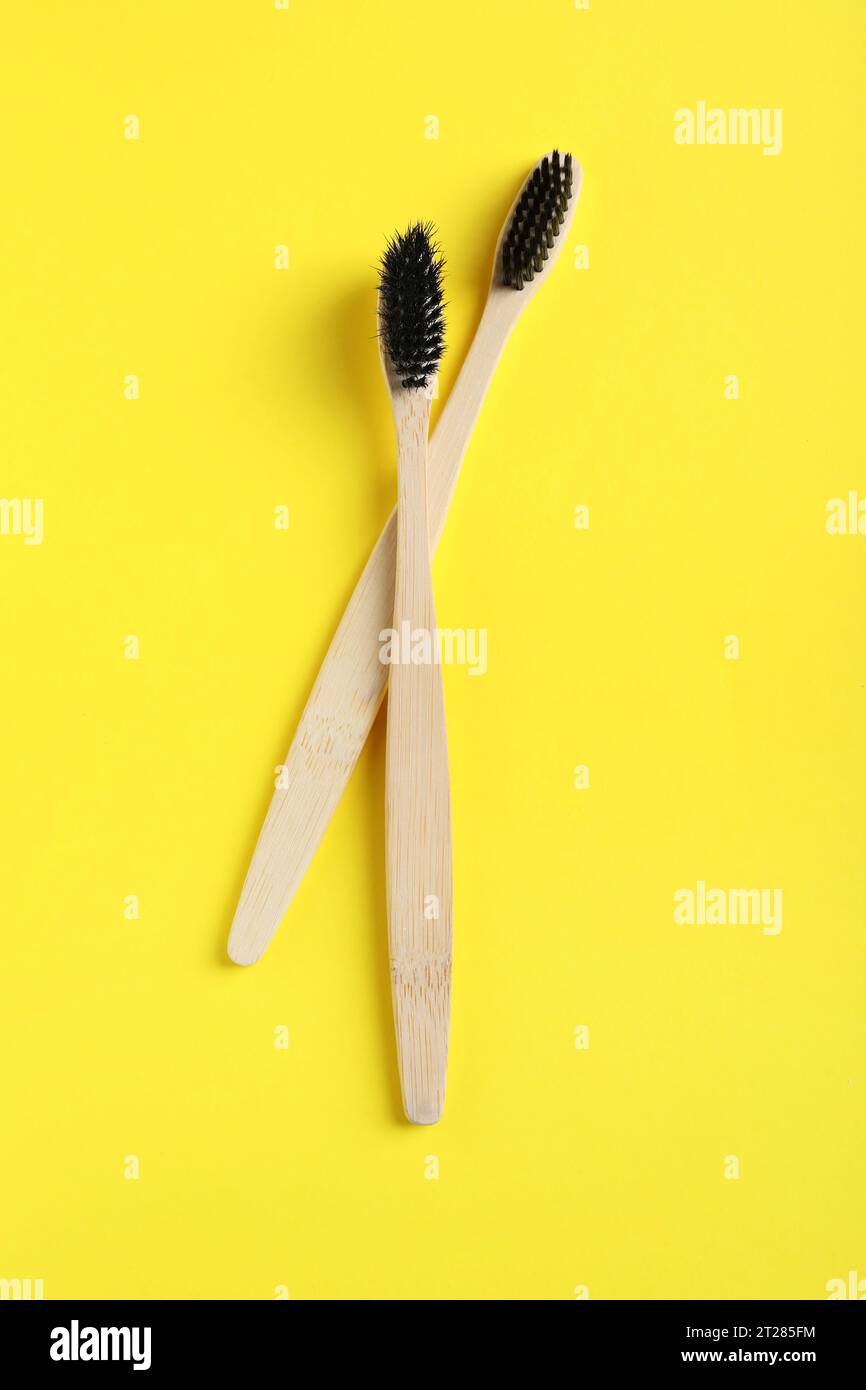 Two bamboo toothbrushes on yellow background, flat lay Stock Photo - Alamy