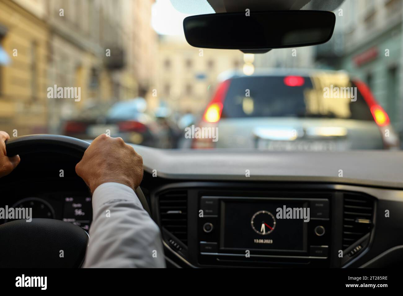 Stuck in traffic jam. Driver holding hands on steering wheel in car