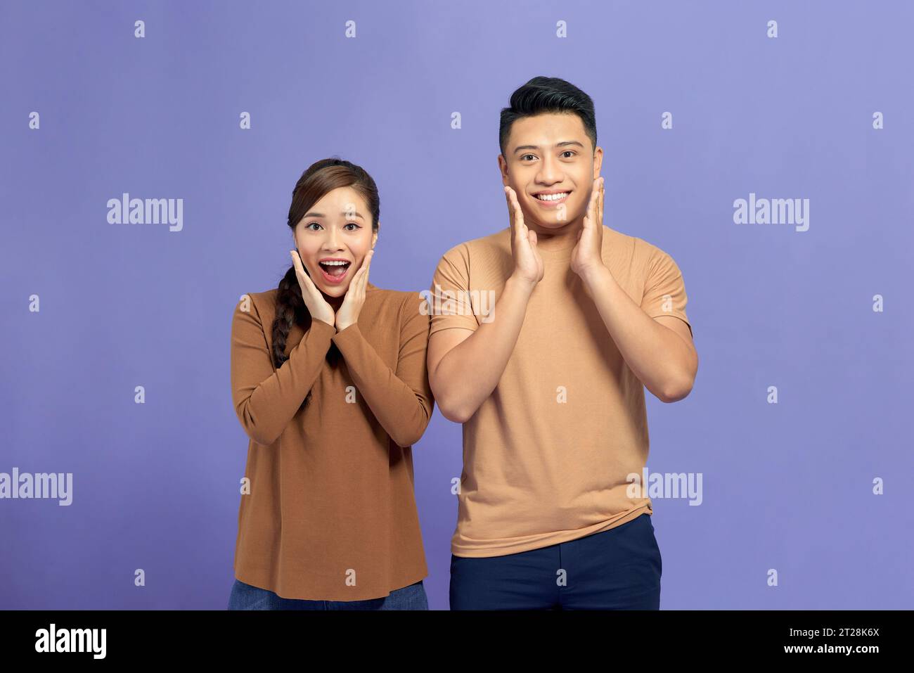 Cheerful young Asian couple being excited with fabulous secret isolated ...