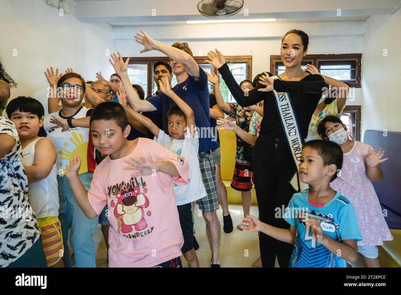 Bangkok, Thailand. 14th Oct, 2023. Tharina Botes, Miss Thailand World 2023 is seen dancing during an English program from Klong Toei Bangkok's biggest slum, at the Bangkok Community Help Foundation Learning and Development Center, at Klong Toei, in Bangkok. Miss Thailand World 2023, Tharina Botes, mixed Thai-South African heritage joined as a volunteer in a free weekly English program for kids and adults, organized by the Bangkok Community Help Foundation, at Klong Toei, Bangkok's biggest slum. (Photo by Nathalie Jamois/SOPA Images/Sipa USA) Credit: Sipa USA/Alamy Live News Stock Photo