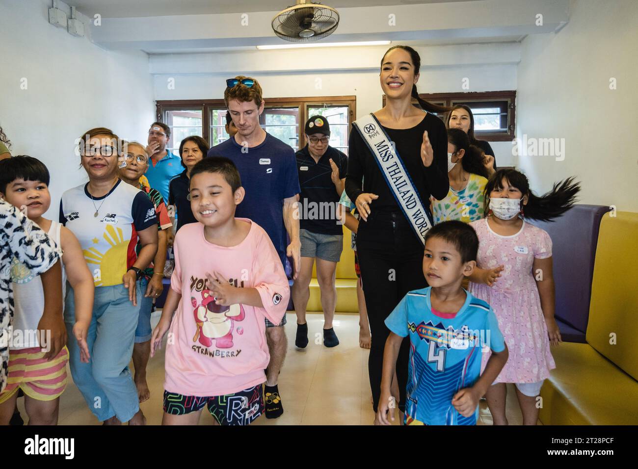 Bangkok, Thailand. 14th Oct, 2023. Tharina Botes, Miss Thailand World 2023 is seen dancing with young children from Klong Toei Bangkok's biggest slum, at the Bangkok Community Help Foundation Learning and Development Center, at Klong Toei, in Bangkok. Miss Thailand World 2023, Tharina Botes, mixed Thai-South African heritage joined as a volunteer in a free weekly English program for kids and adults, organized by the Bangkok Community Help Foundation, at Klong Toei, Bangkok's biggest slum. (Photo by Nathalie Jamois/SOPA Images/Sipa USA) Credit: Sipa USA/Alamy Live News Stock Photo