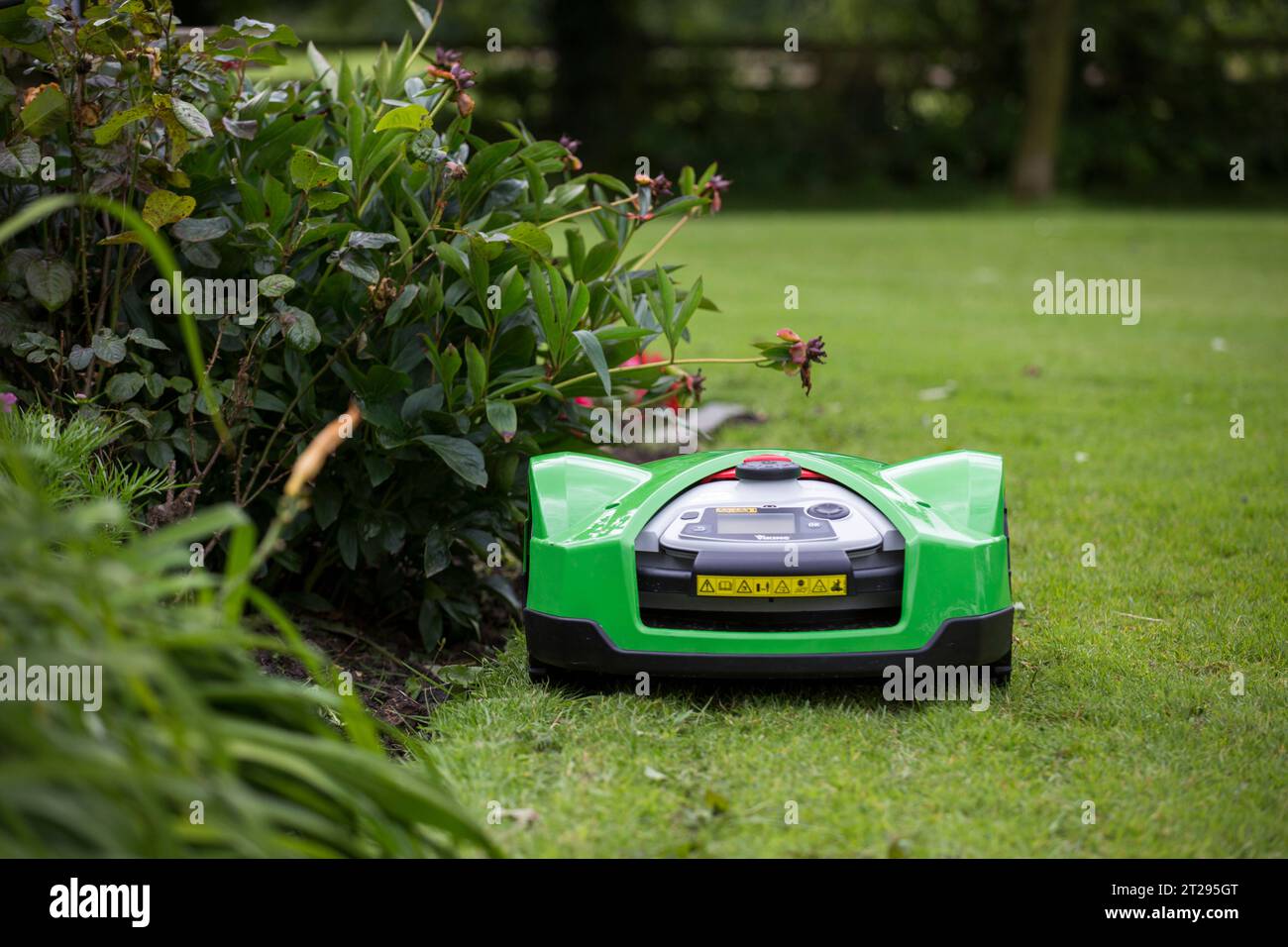 An iMow automated lawn mower in a garden in the UK Stock Photo