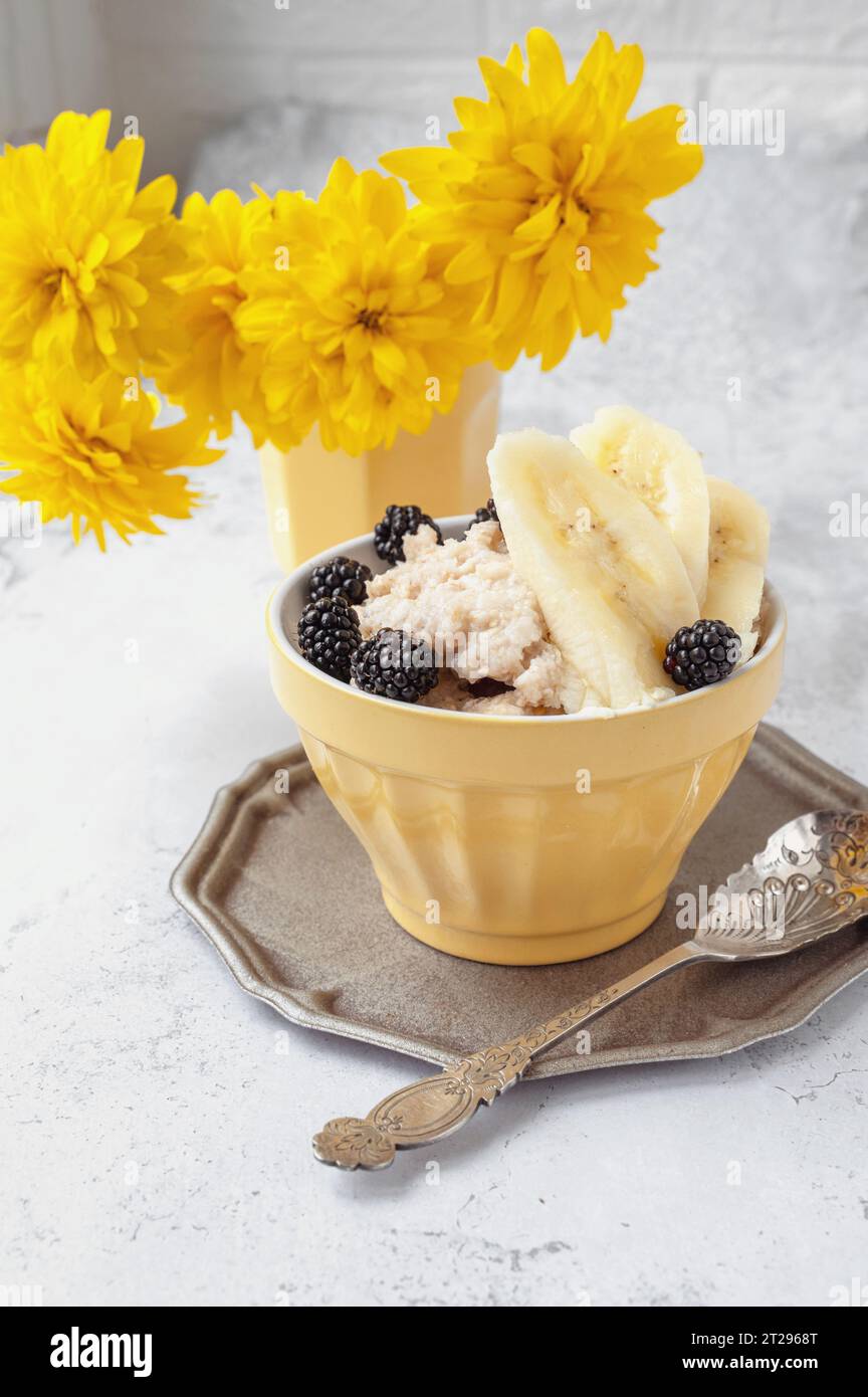 oatmeal for breakfast. Healthy breakfast of oatmeal, banana and blackberries and mulberries. Stock Photo