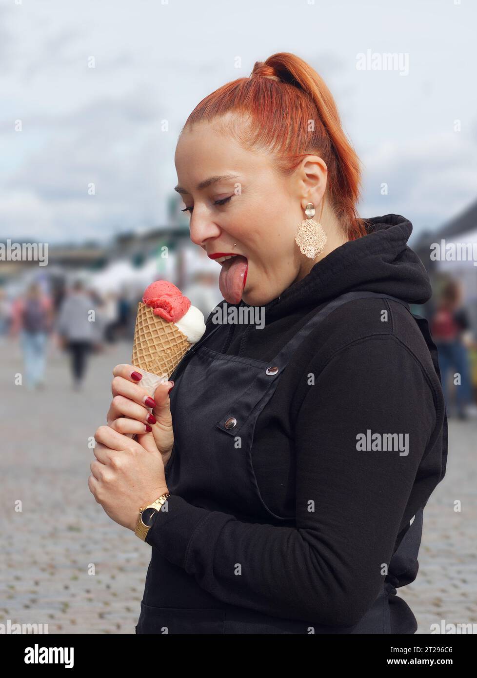 Young pretty woman, visitor of autumn street food market posing with cone of ice cream in Prague Stock Photo