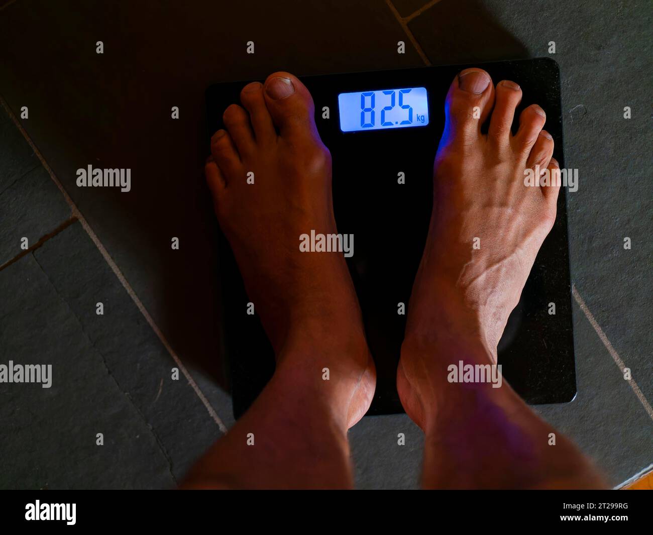 Men's feet on personal scale, body weight, measure, digital weight