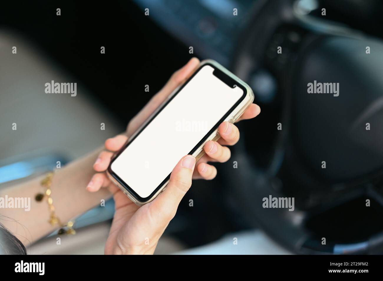 Young woman using mobile phone while driving car for navigation or ...