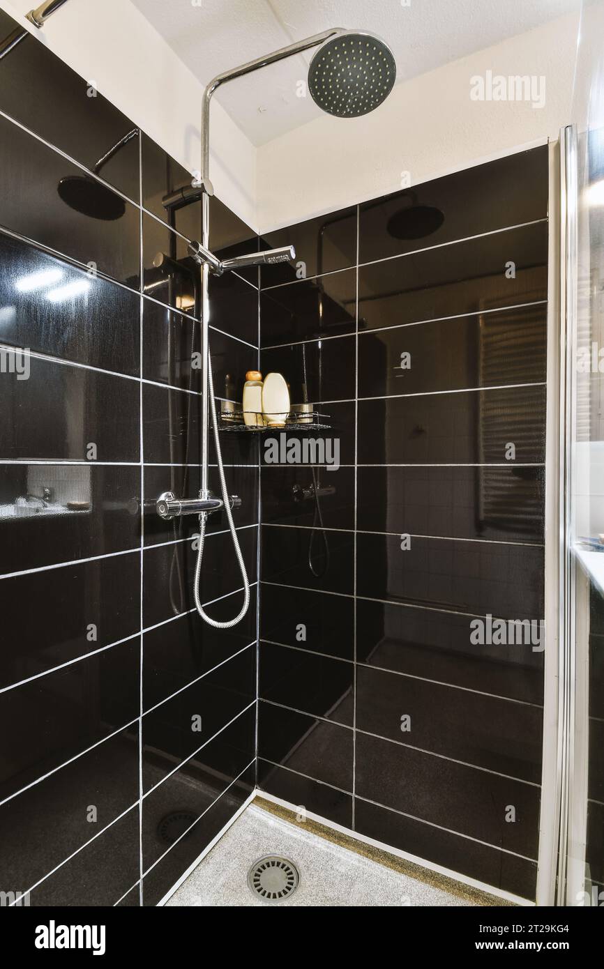 New black shower head on holder in white tiled bathroom in modern apartment  Stock Photo - Alamy