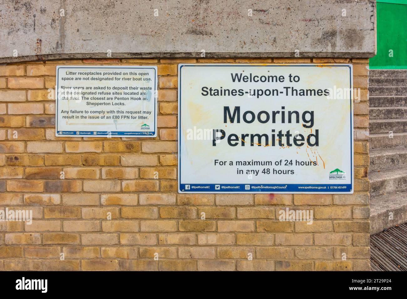 Signs attached to a brick wall next to the River Thames at Staines-upon-Thames informing people that Mooring is permitted Stock Photo