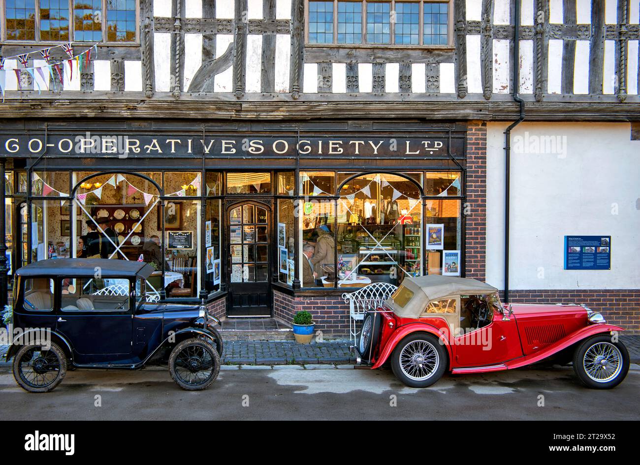 Avoncroft Museum of Historic Buildings site with Co-Op store back drop and 1929 Austin 7 and 1947 MG TC vintage cars., Bromsgrove, England UK Stock Photo