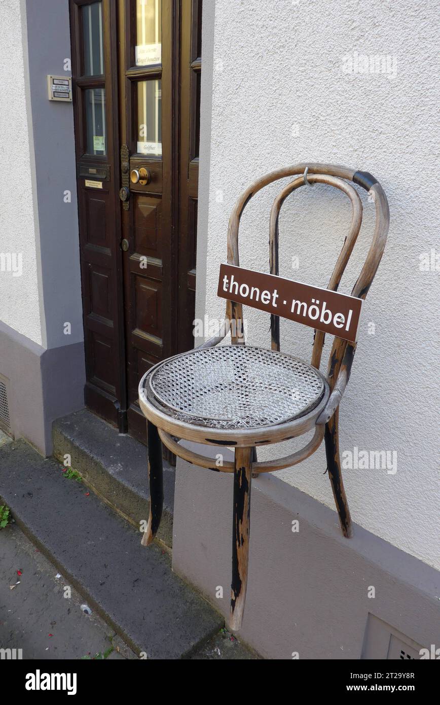Klassischer Holzstuhl der Firma Thonet, aufgehängt an der Hausfassade eines Antiquitätenhändlers in Boppard am Rhein Rheinland-Pfalz. Der Gründer des Familienunternehmens Thonet, Michael Thonet 1796 - 1871, war ein deutsch-österreichischer Tischlermeister, der zunächst eine Tischlerei in Boppard betrieb. 1842 zog er nach Wien. Seit 1953 hat die Thonet GmbH ihren Hauptsitz in Frankenberg Hessen. Kaffeehausstühle von Thonet gelten als Designklassiker. *** Classic wooden chair of the company Thonet, hung on the facade of a house antique dealer in Boppard on the Rhine Rhineland Palatinate The foun Stock Photo