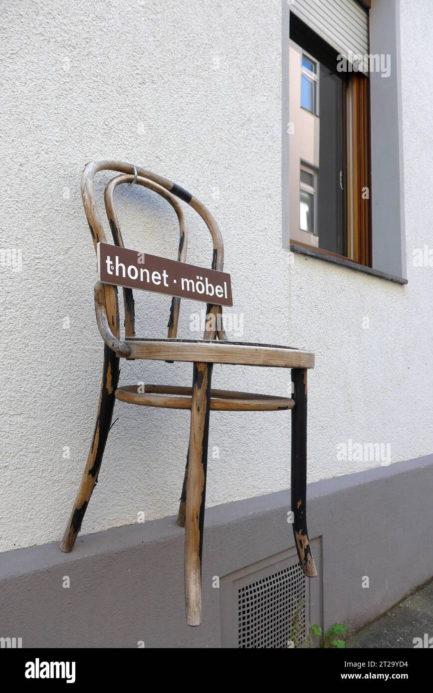 Klassischer Holzstuhl der Firma Thonet, aufgehängt an der Hausfassade eines Antiquitätenhändlers in Boppard am Rhein Rheinland-Pfalz. Der Gründer des Familienunternehmens Thonet, Michael Thonet 1796 - 1871, war ein deutsch-österreichischer Tischlermeister, der zunächst eine Tischlerei in Boppard betrieb. 1842 zog er nach Wien. Seit 1953 hat die Thonet GmbH ihren Hauptsitz in Frankenberg Hessen. Kaffeehausstühle von Thonet gelten als Designklassiker. *** Classic wooden chair of the company Thonet, hung on the facade of a house antique dealer in Boppard on the Rhine Rhineland Palatinate The foun Stock Photo