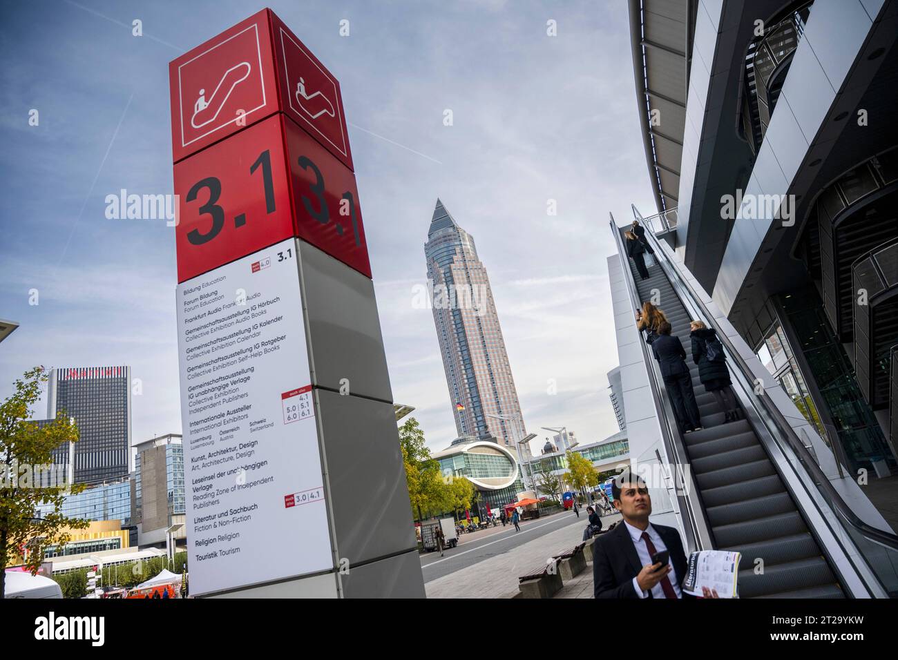 Hinweisstele zur Frankfurter Buchmesse, Aussenansicht mit Messeturm Foto vom 18.10.2023. Die 75. Frankfurter Buchmesse oeffnet am 18.10. ihre Pforten. Die ersten beiden Messetage sind Fachpublikum vorbehalten, von Freitag bis Sonntag oeffnet die Literaturschau fuer alle Interessierten. Die Frankfurter Buchmesse ist nach eigenen Angaben das international groesste Zusammentreffen in der Publishing-Branche. Siehe epd-Meldung vom 18.10.2023 EDITORIAL USE ONLY *** Information stele for the Frankfurt Book Fair, exterior view with fair tower Photo from 18 10 2023 The 75 Frankfurt Book Fair opens its Stock Photo