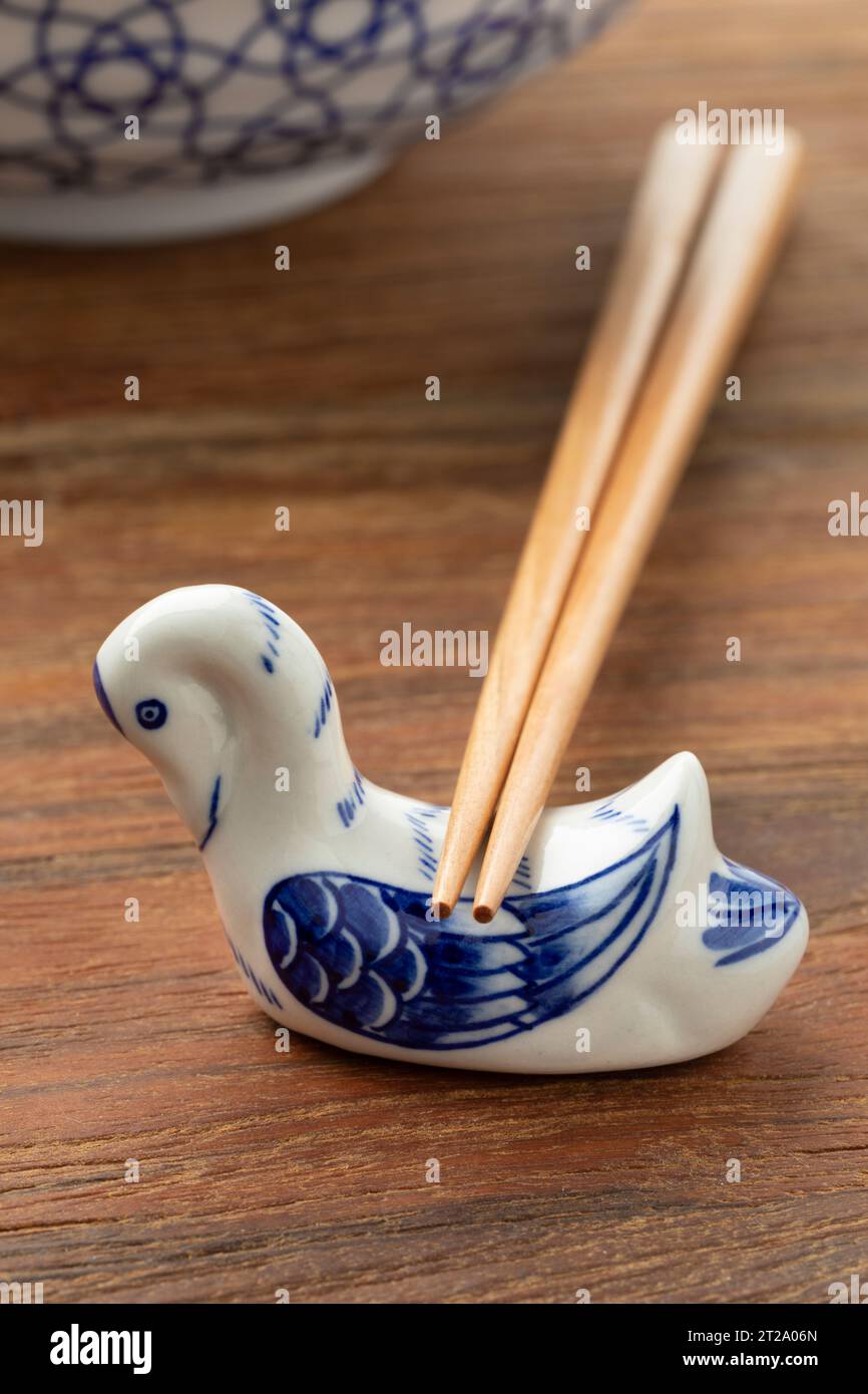 Ceramic chopstick holder in the shape of a swan on a wooden table close up Stock Photo