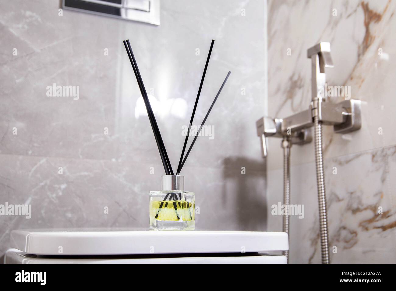 Aroma diffuser air freshener stands on a hanging toilet bowl in the