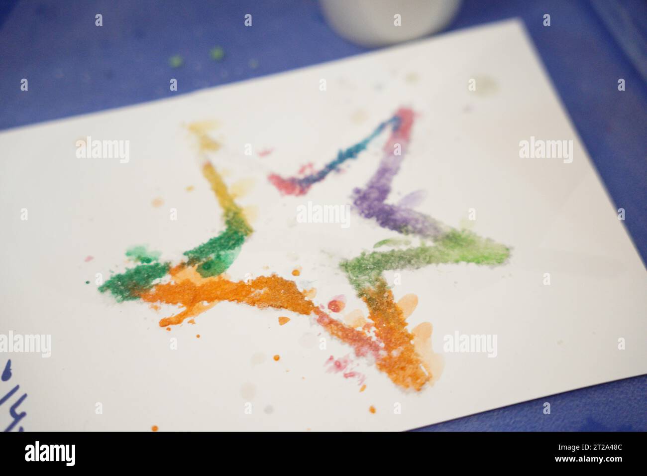 Painting in salt, kids doing art activities at summer camp. star with salt and paints. with their names on arabic language Stock Photo