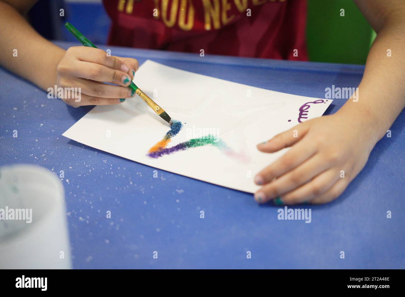 Painting in salt, kids doing art activities at summer camp. star with salt and paints. with their names on arabic language Stock Photo