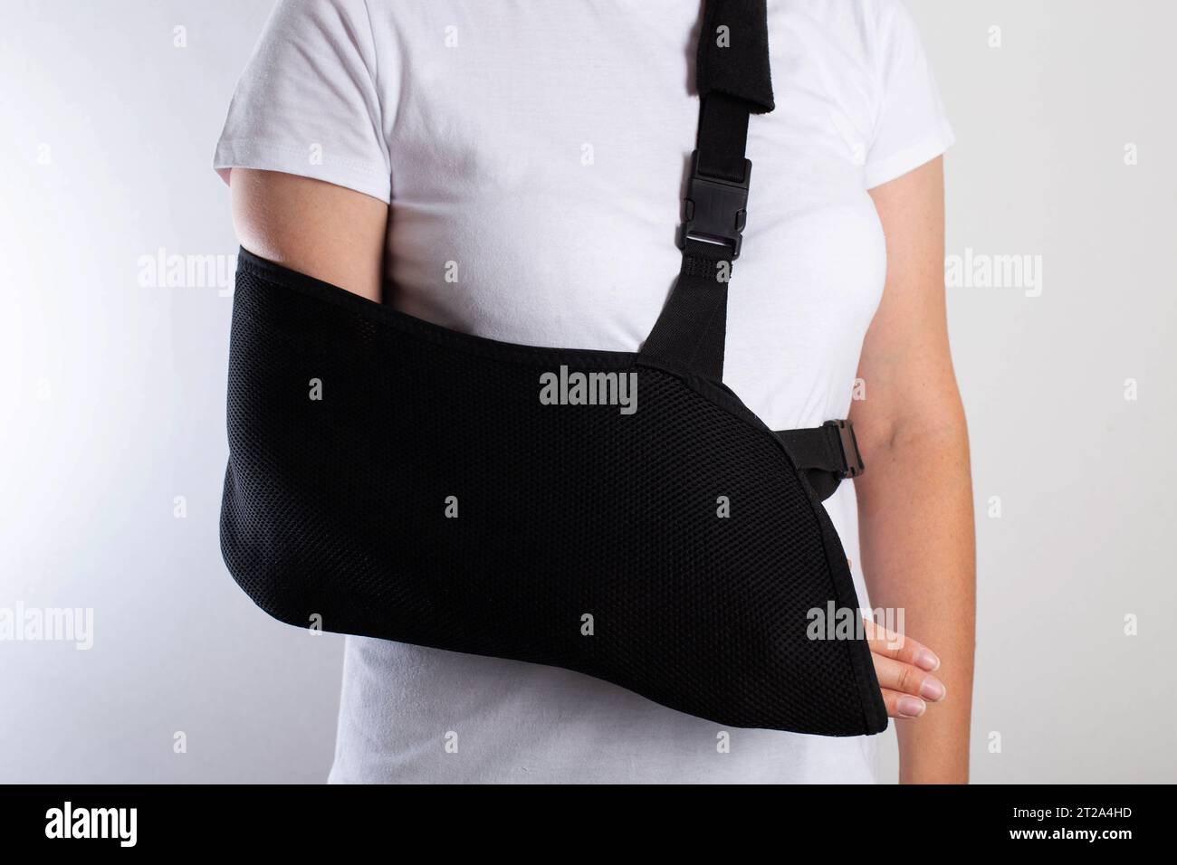 A girl in white with a black support bandage for her arm after a