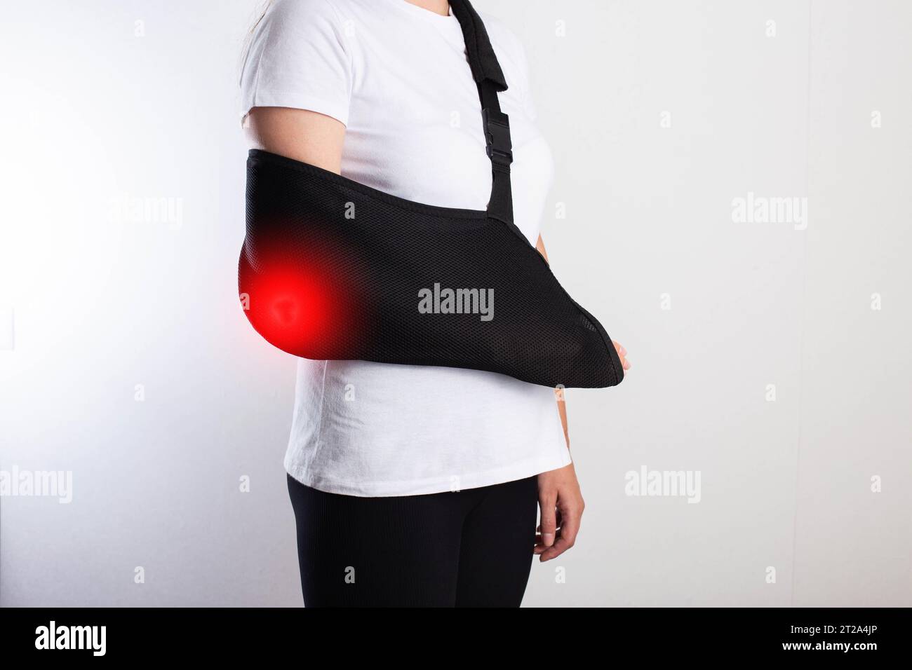 A girl in white with a black support bandage for her arm after a