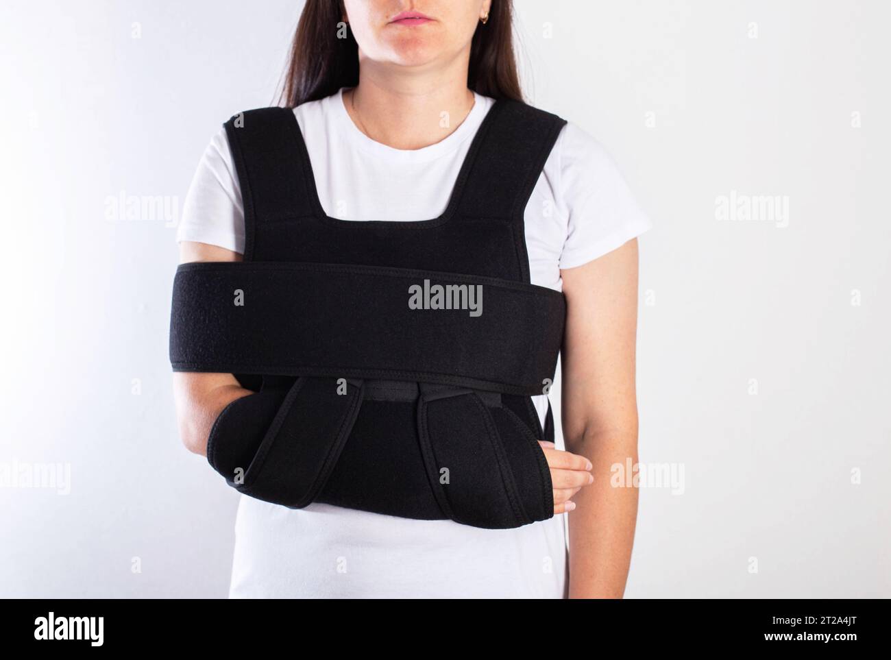 A girl in a medical brace on the shoulder joint for rehabilitation after a collarbone fracture and dislocation. Shoulder sprain. Stock Photo
