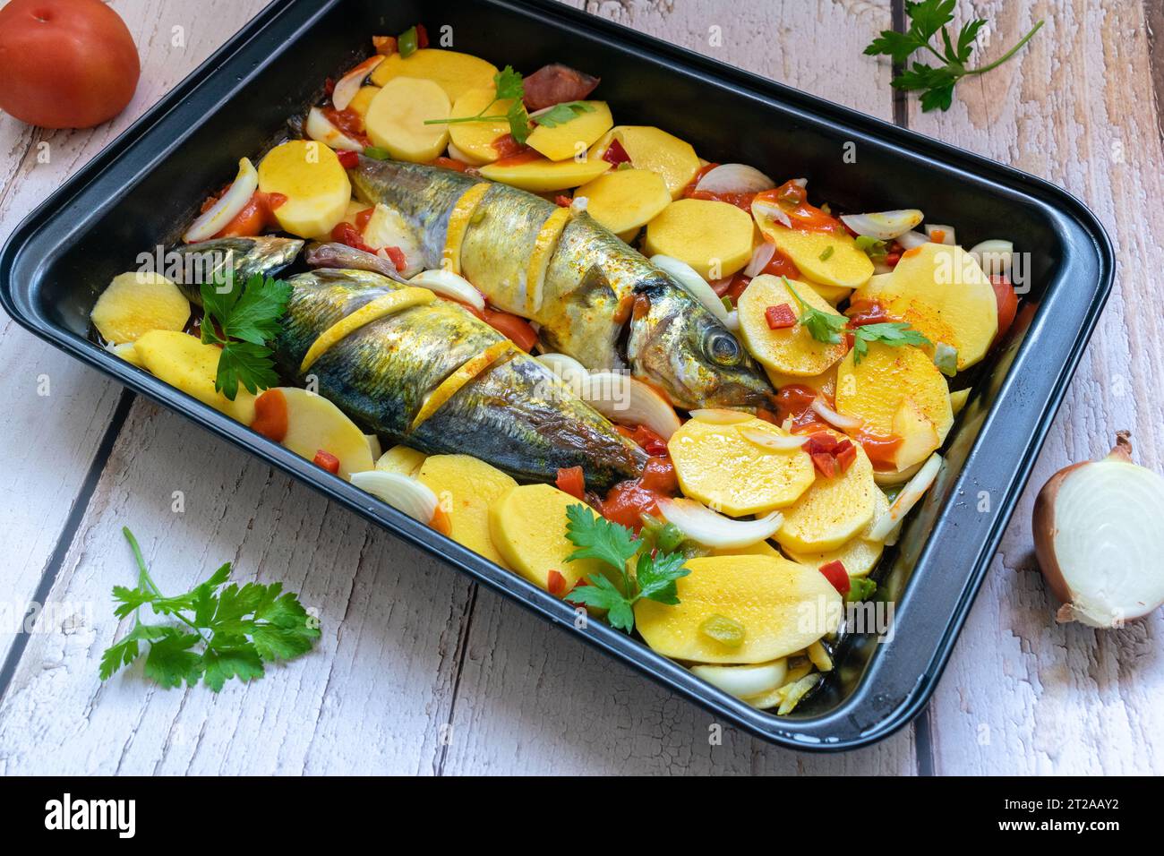 Delicious baked mackerel with potatoes and tomato, onion, lemon and