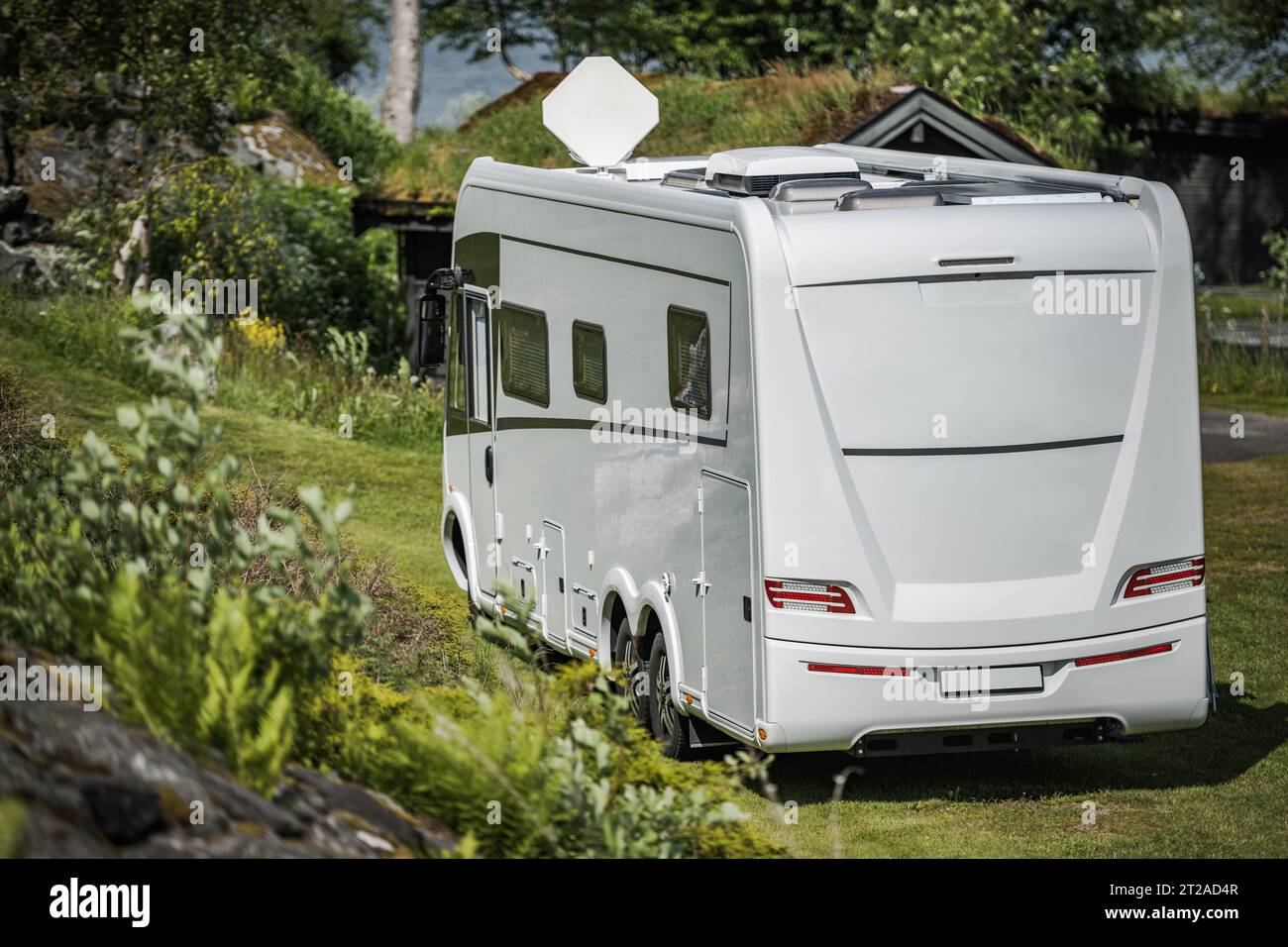 Modern Three Axle Full Size Full Integral Camper Van with Satellite Dish on the Roof Stock Photo