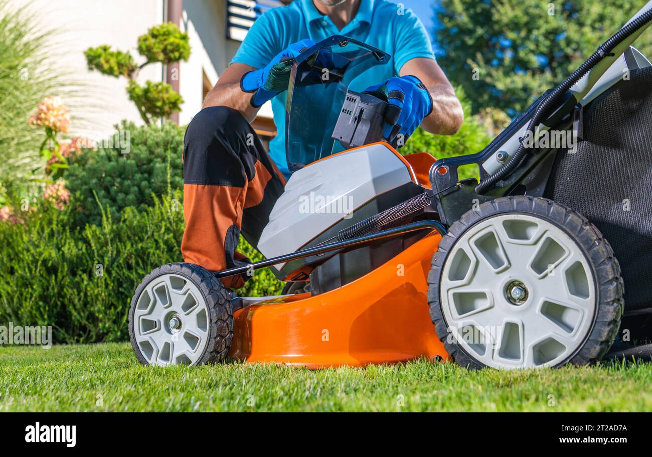 Homeowner Replacing Dead Battery In His Modern Cordless Grass Mower