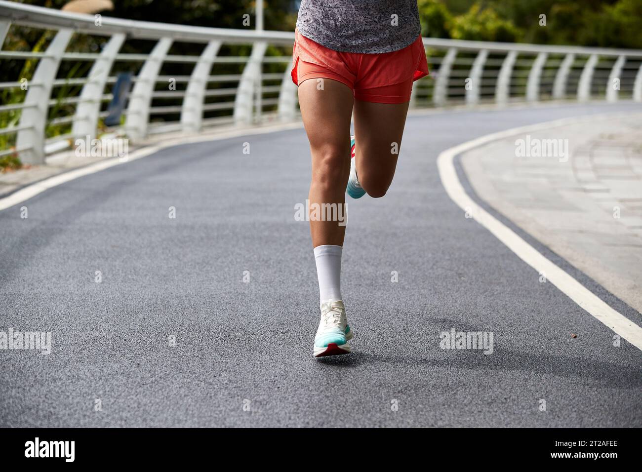 closeup shot of legs and feet of asian woman female runner running jogging outdoors Stock Photo
