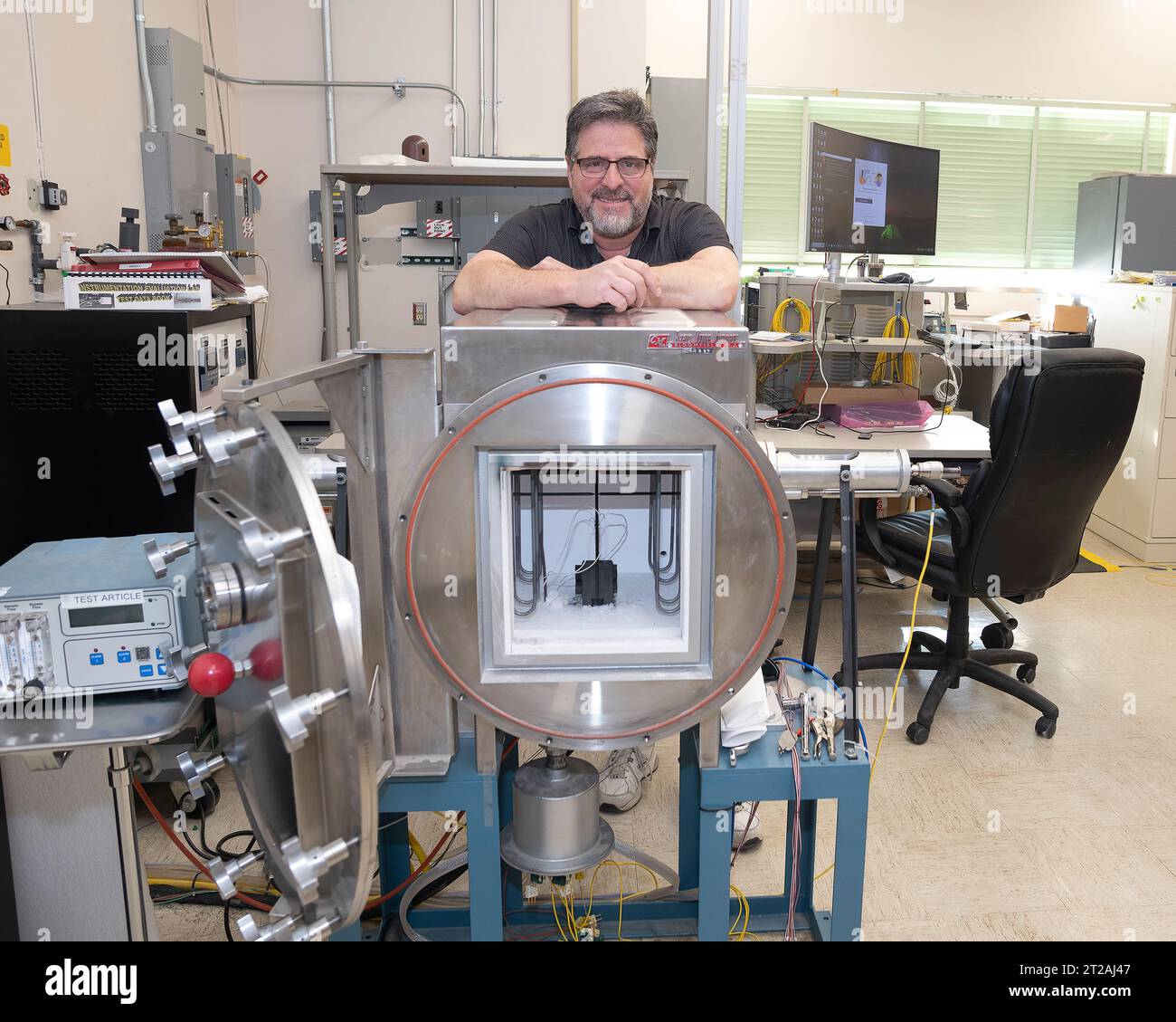 . Anthony piazza, a researcher at NASA’s Armstrong Flight Research center in Edwards, California, works with high-temperature strain sensors. This test article is a bending load bar, which enables high-temperature optical strain sensor research up to 1,800 degrees Fahrenheit. Stock Photo