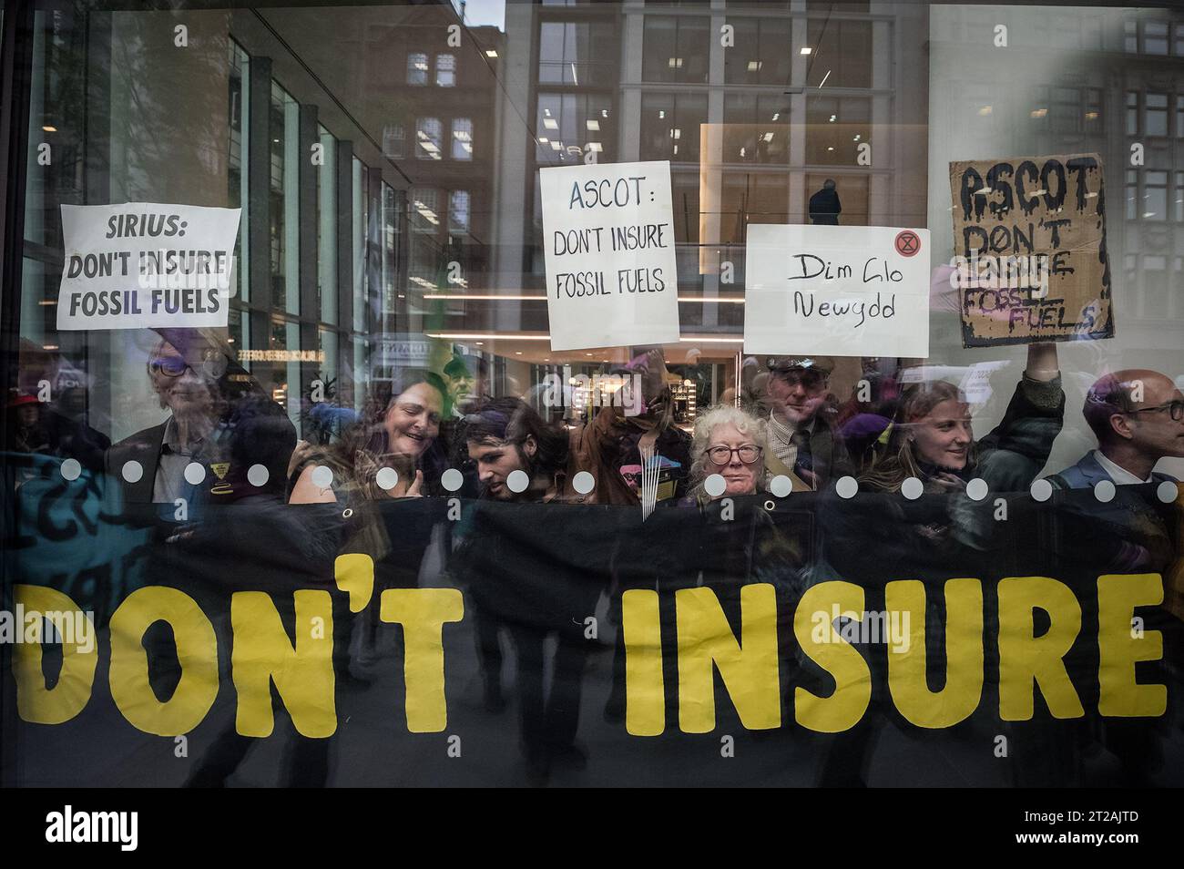 London, UK. 18th October, 2023. 'Oily Money Out Climate change activists from Extinction Rebellion (XR) occupy the lobby area of offices of Ascot Group to demand they refuse to insure major oil companies in a bid to end to fossil fuels and to 'stop the flow of oil'. Credit: Guy Corbishley/Alamy Live News Stock Photo