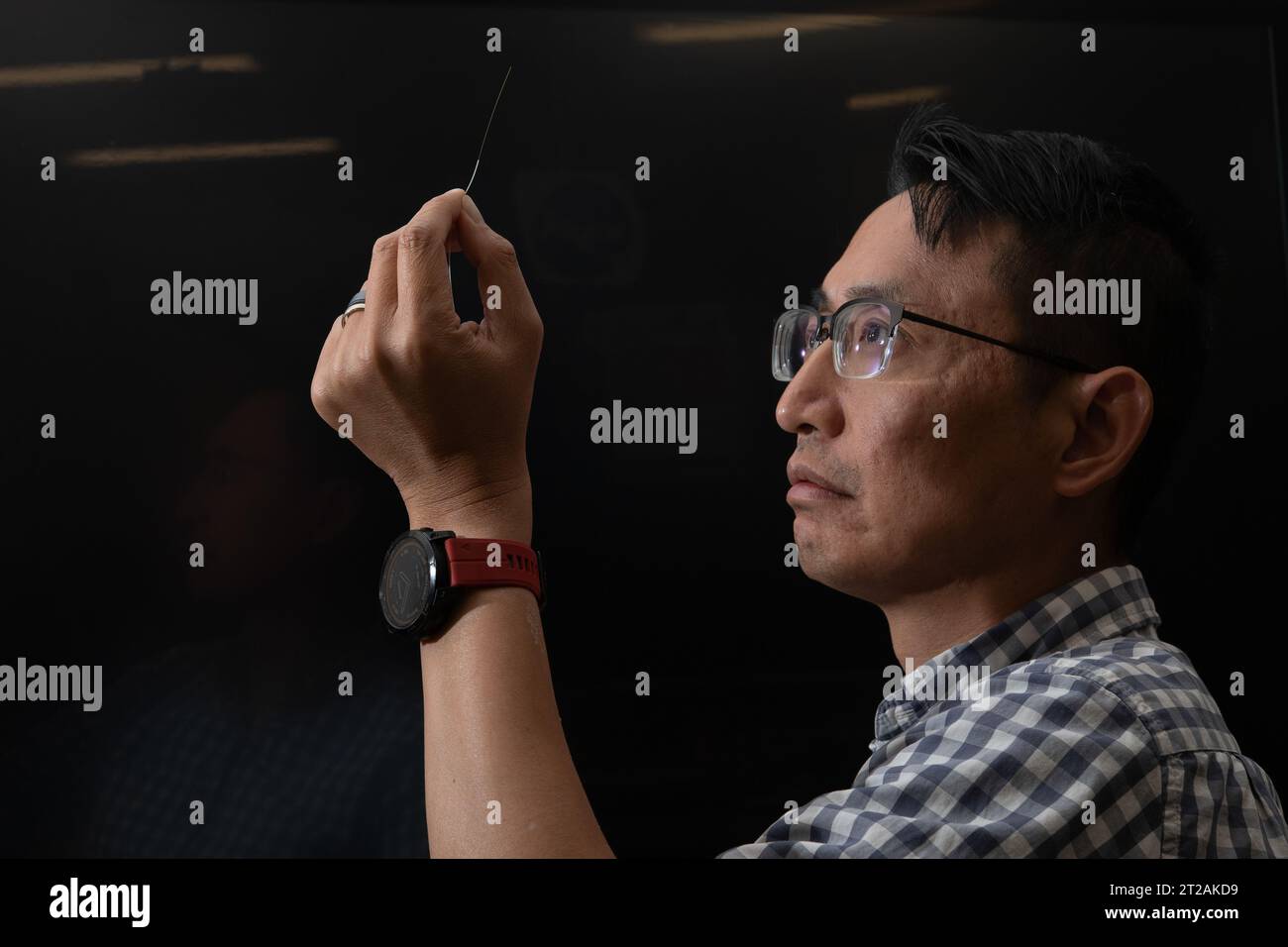 Patrick Chan examined an optic fiber in a protective sleeve as NASA ...