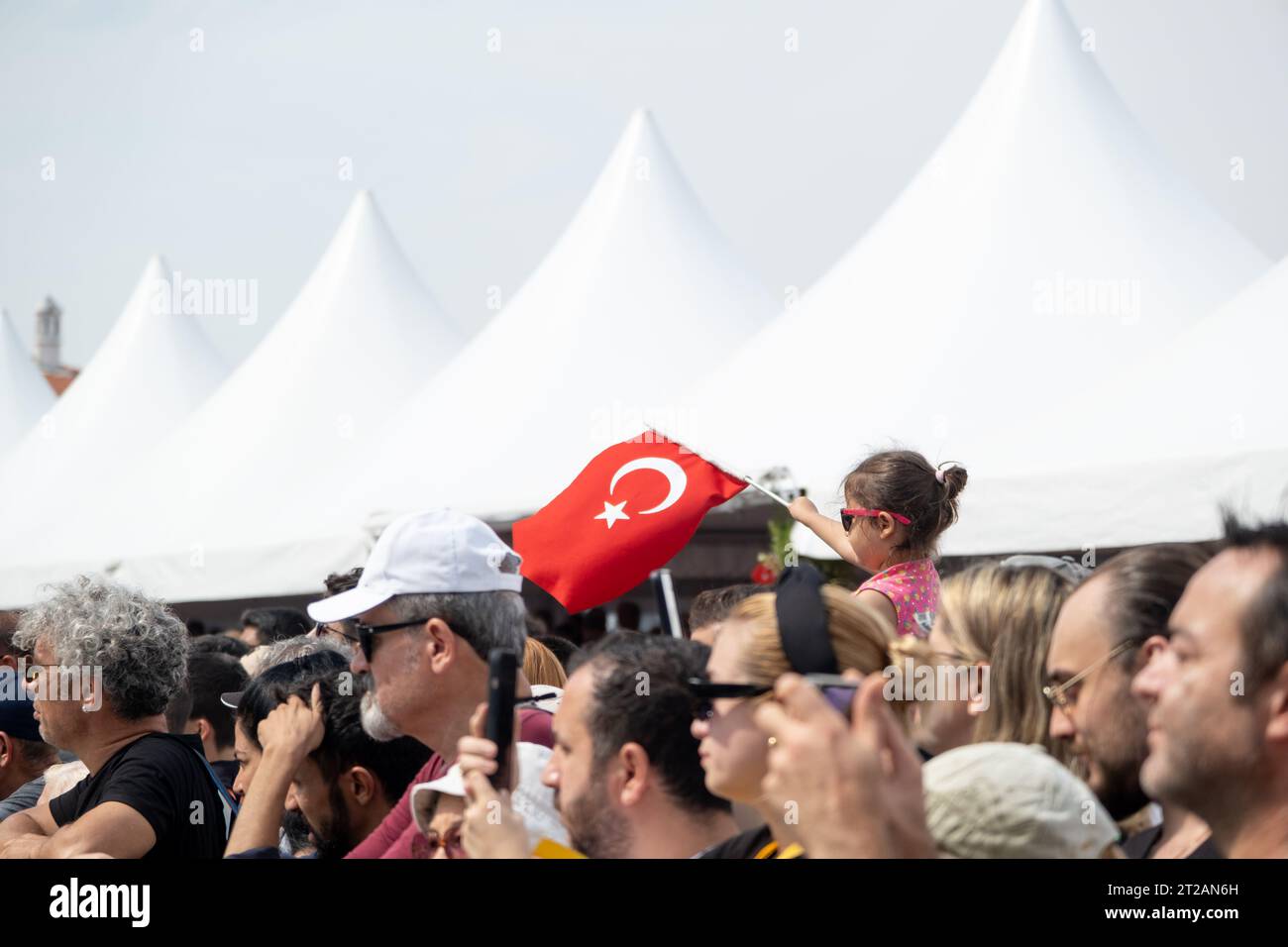Izmir, Turkey, September 9, 2023: A heartwarming moment capturing an 8-9-year-old girl with sunglasses, perched on her father's shoulders, waving the Stock Photo