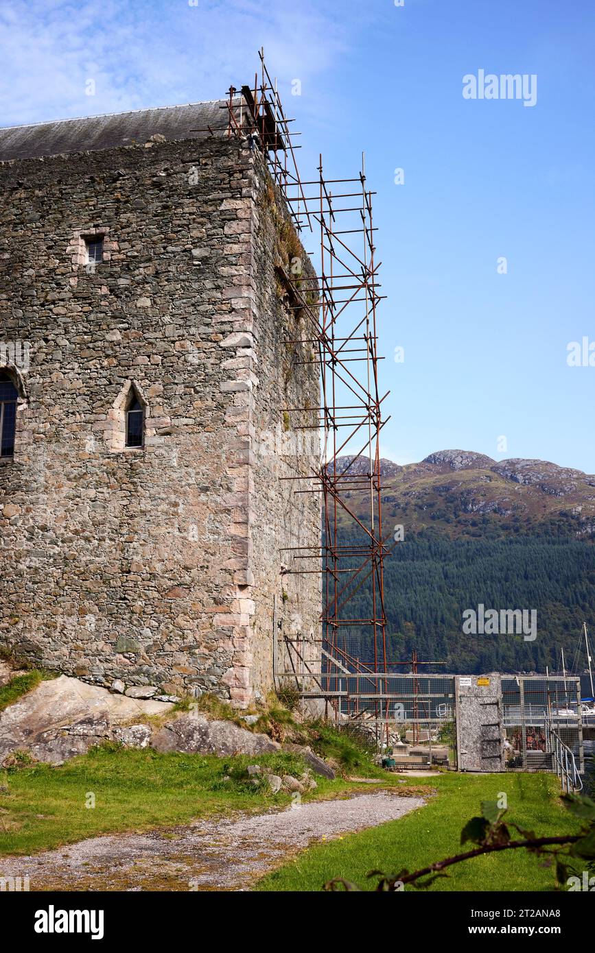 Cloaked with scaffolding, on going repairs and maintenance to historic Carrick Castle on the shore of Loch Goil. Argyll Stock Photo