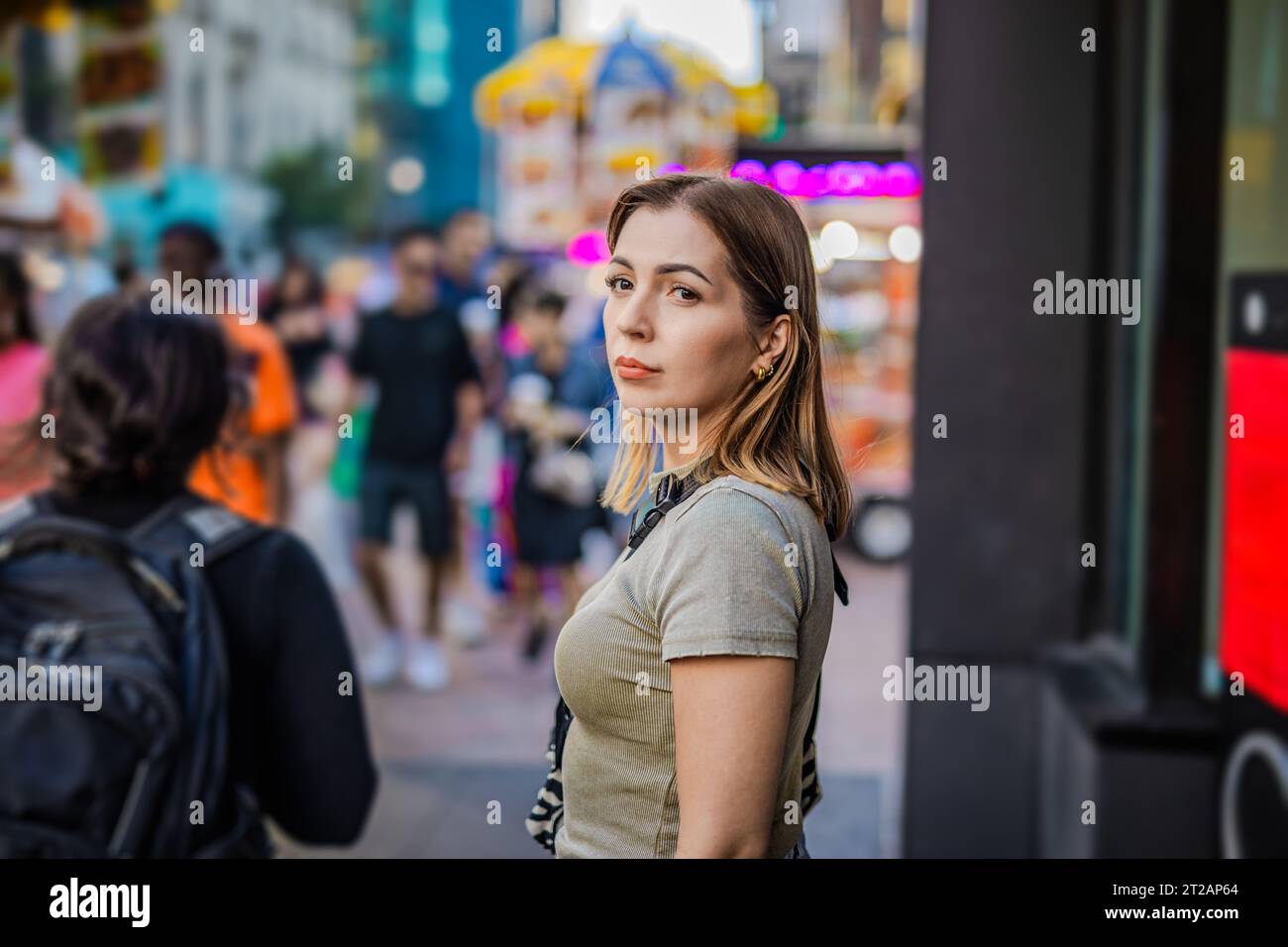 A charming blonde girl in the foreground with the vibrant backdrop of New York. Stock Photo