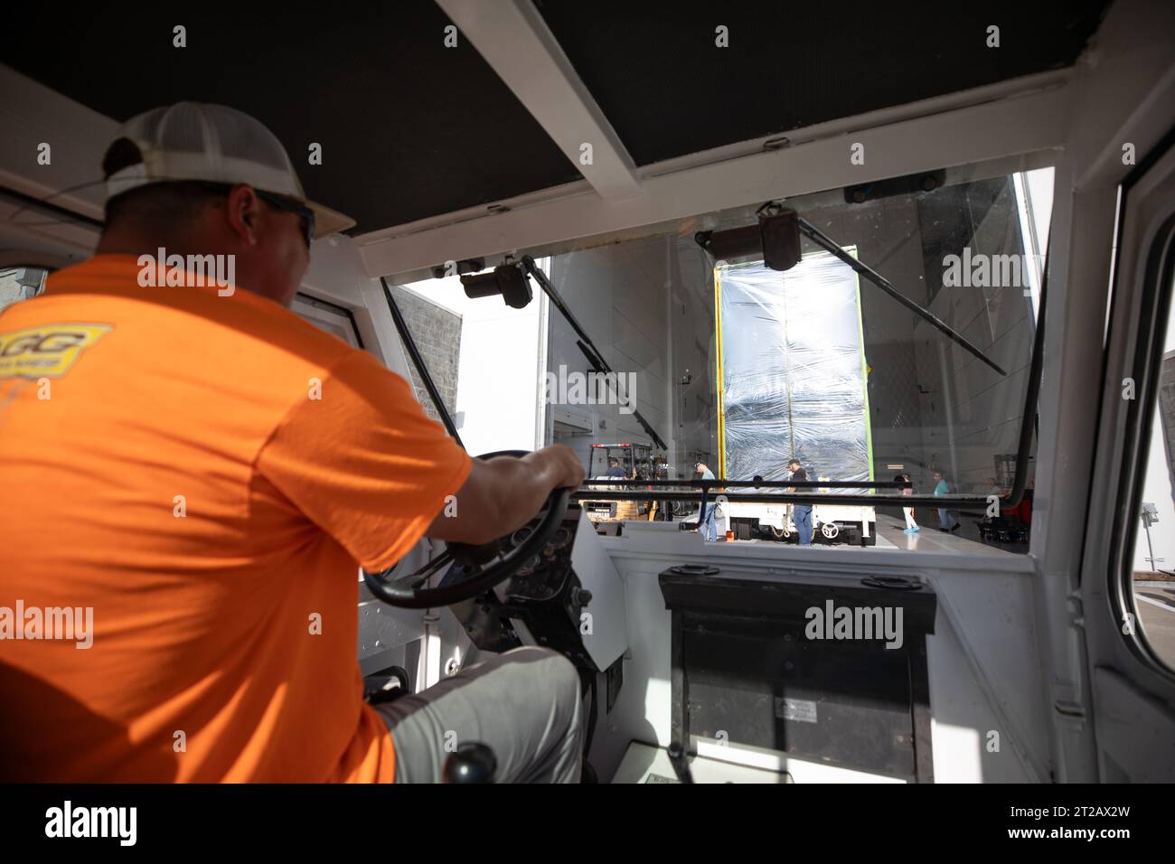 NASA's Psyche Spacecraft Move at Astrotech. A driver uses a transport vehicle to move NASA’s Psyche spacecraft, secured for transport, into the entrance of Building 9 at the Astrotech Space Operations Facility near the agency’s Kennedy Space Center in Florida on Aug. 14, 2023.  Psyche will explore its namesake, a metal-rich asteroid orbiting the Sun between Mars and Jupiter. Psyche has NASA’s Deep Space Optical Communications (DSOC) technology demonstration onboard the spacecraft. DSOC will be the agency's first demonstration of optical communication beyond the Moon. Psyche will launch atop a Stock Photo