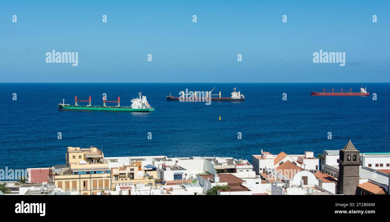 Freighter in the sea with roofs of the city of Las Palmas Gran Canaria, Spain  in the foreground Stock Photo