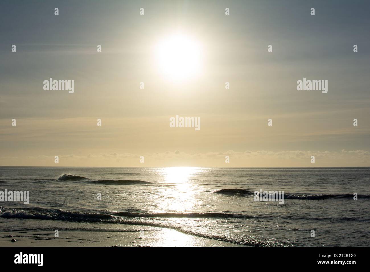 Sunrise on the sea around a sandy beach Stock Photo